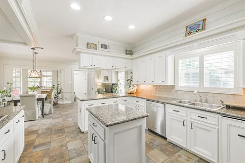 a kitchen with sink stove and cabinets