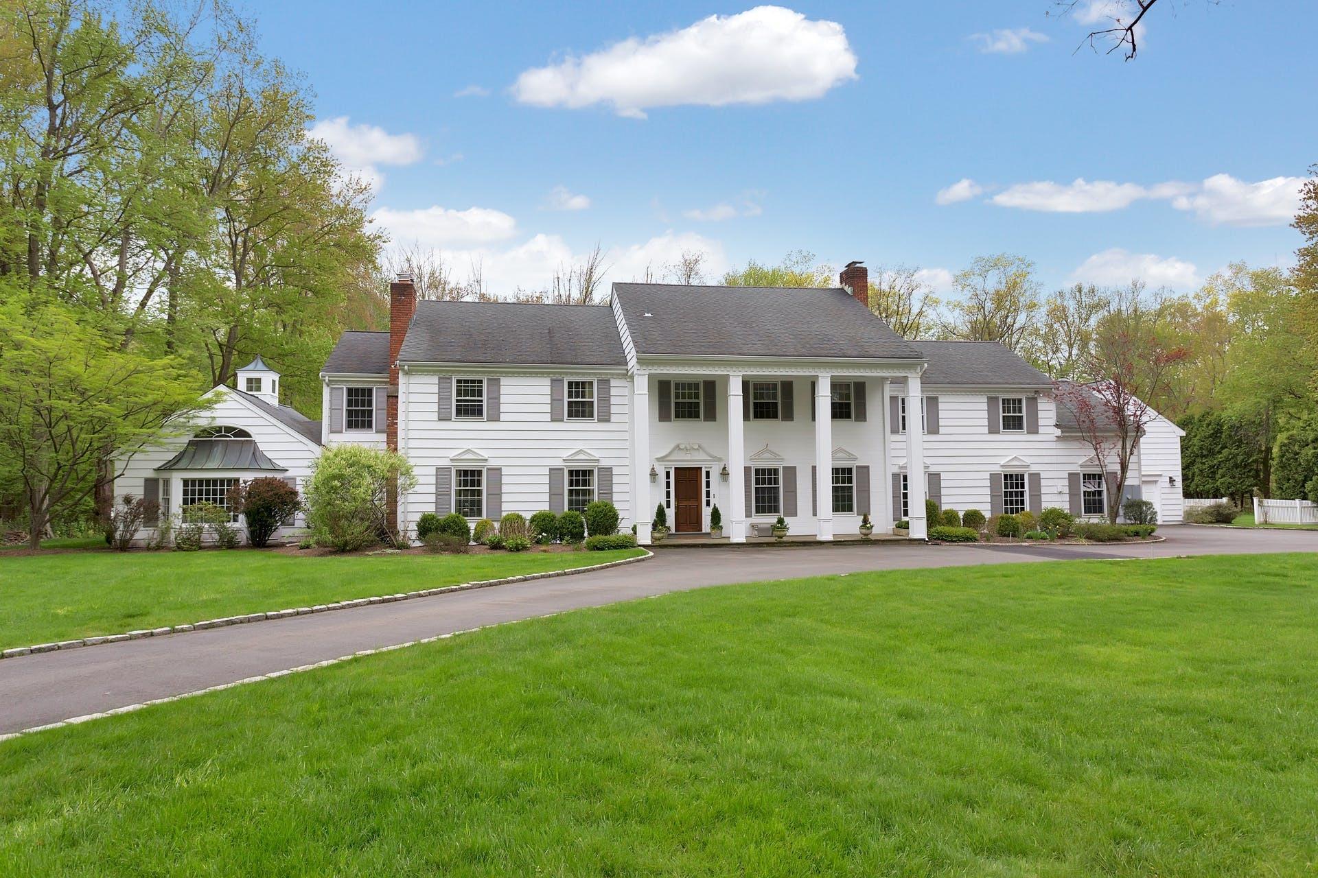 100 Stephen Mather Road Darien, CT 06820 - Photo 1 of 38 a front view of a house with a garden