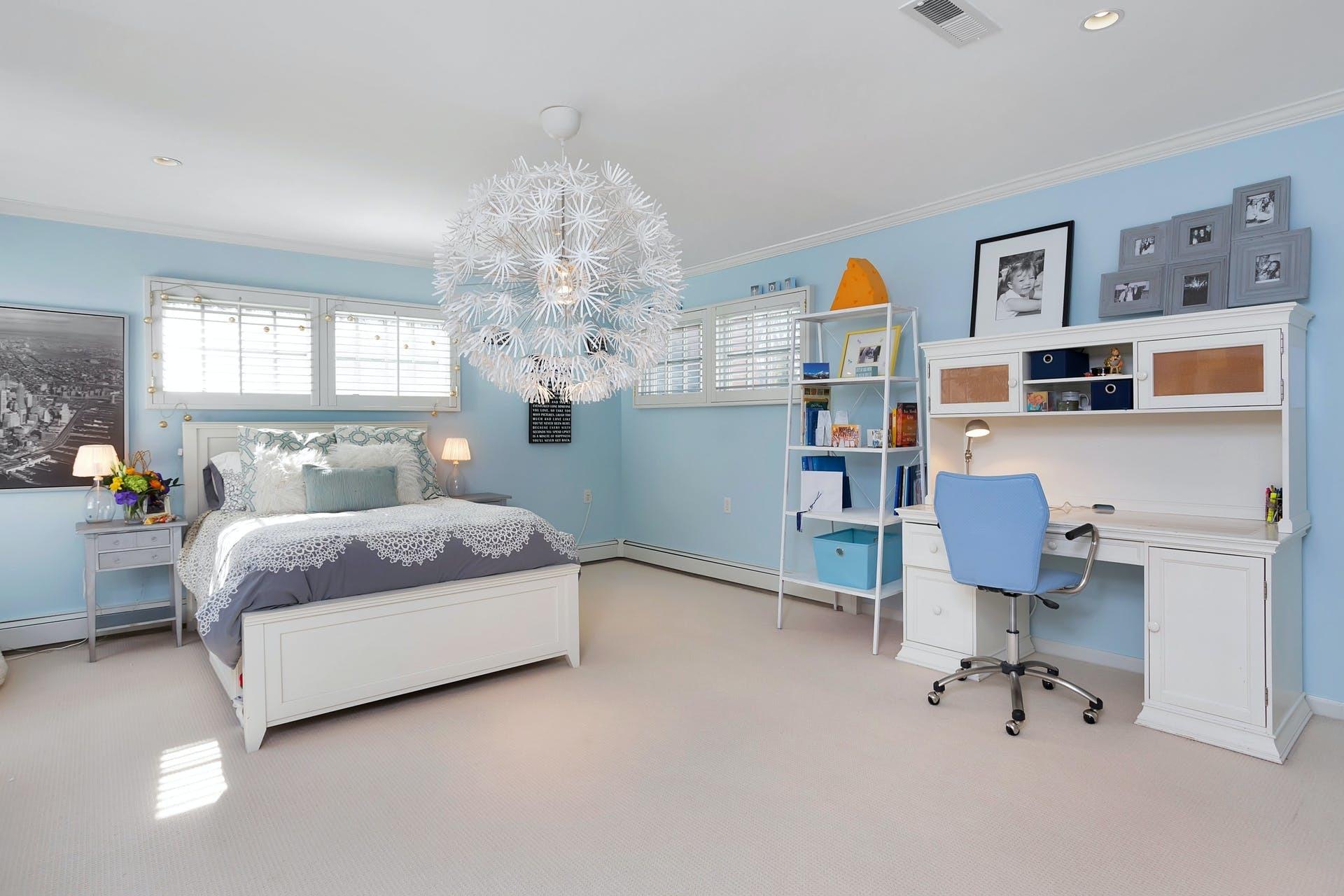100 Stephen Mather Road Darien, CT 06820 - Photo 26 of 38 a bedroom with a bed and a chandelier