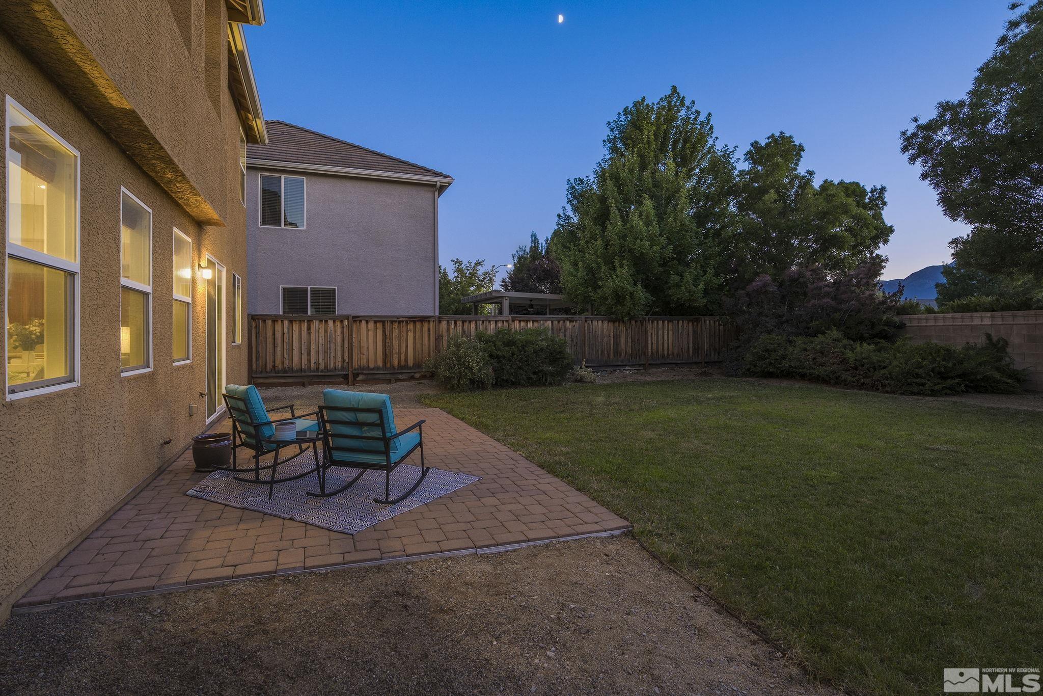 11225 Messina Way Reno, NV 89521 - Photo 32 of 40 a view of a patio with table and chairs and potted plants with wooden fence