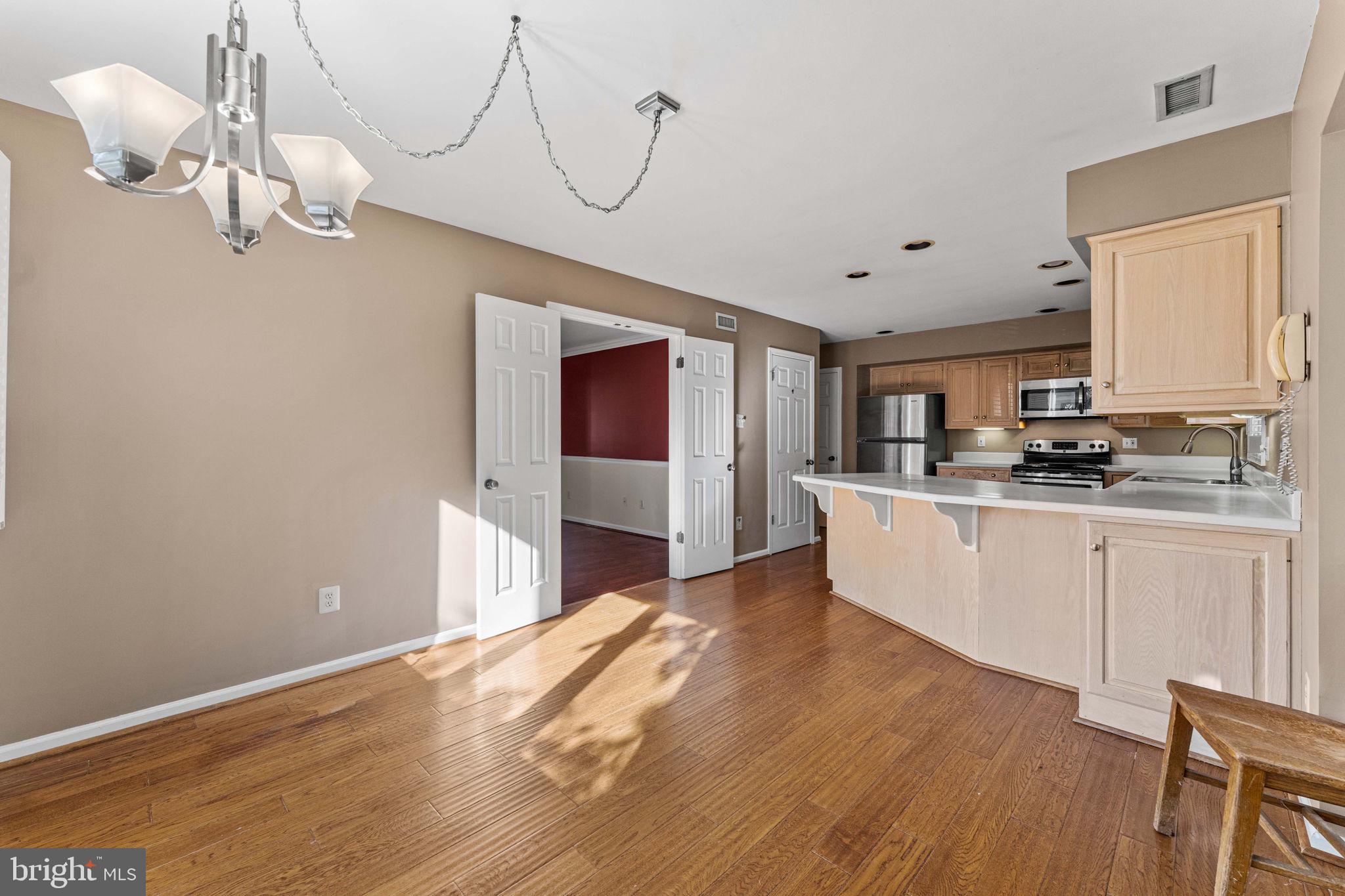 975 Kennett Way West Chester, PA 19380 - Photo 18 of 48 a kitchen with cabinets wooden floor and a chandelier