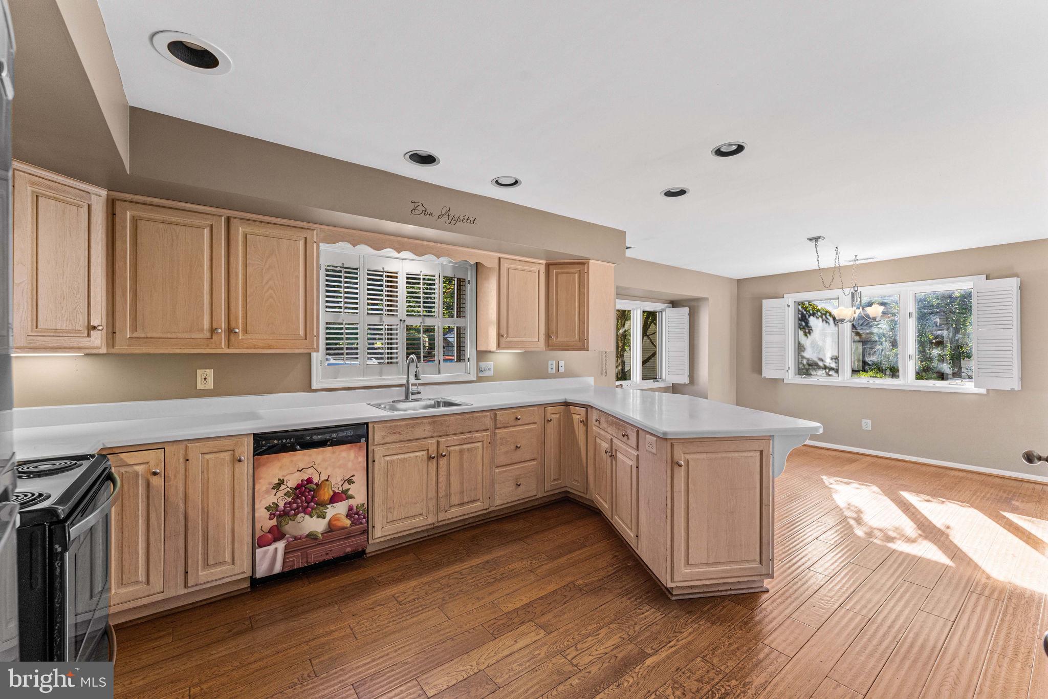 975 Kennett Way West Chester, PA 19380 - Photo 21 of 48 a kitchen with stainless steel appliances granite countertop a stove a sink and white cabinets with wooden floor