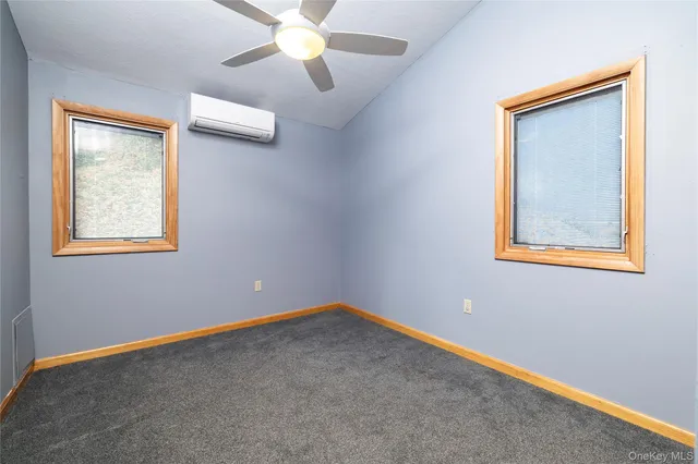 an empty room with a window and a fan