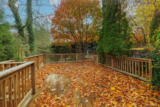 a view of backyard with wooden fence and trees
