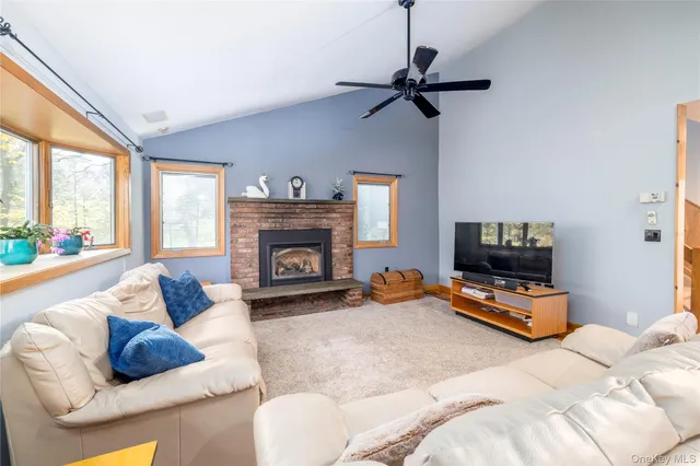 a living room with furniture a fireplace and a flat screen tv