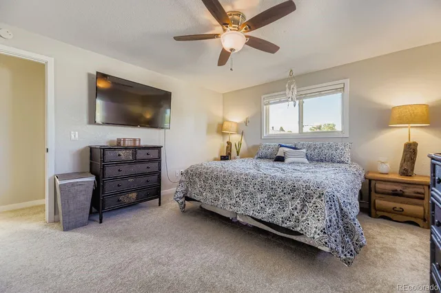 a bedroom with a bed a dresser and a chandelier