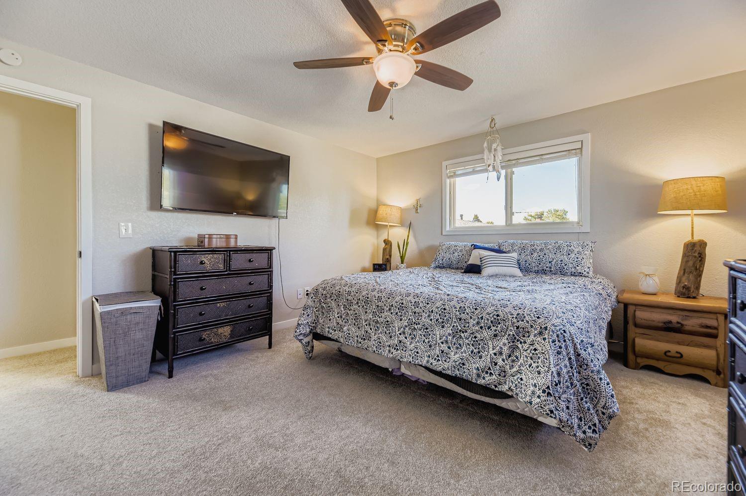 7161 South Franklin Street Centennial, CO 80122 - Photo 15 of 28 a bedroom with a bed a dresser and a chandelier