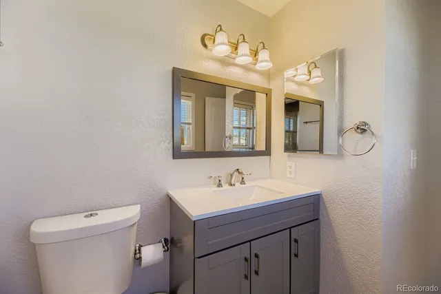 a bathroom with a sink a toilet and mirror