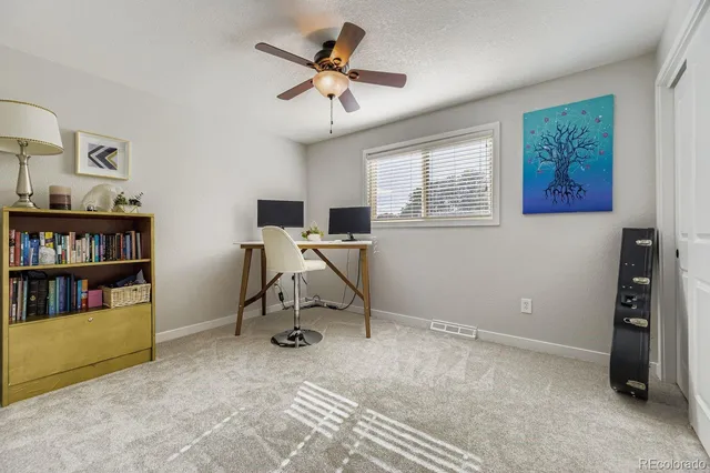 a view of a workspace with furniture and a window
