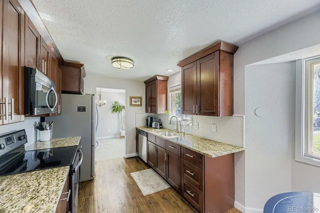 a bathroom with a granite countertop double vanity sink and a mirror