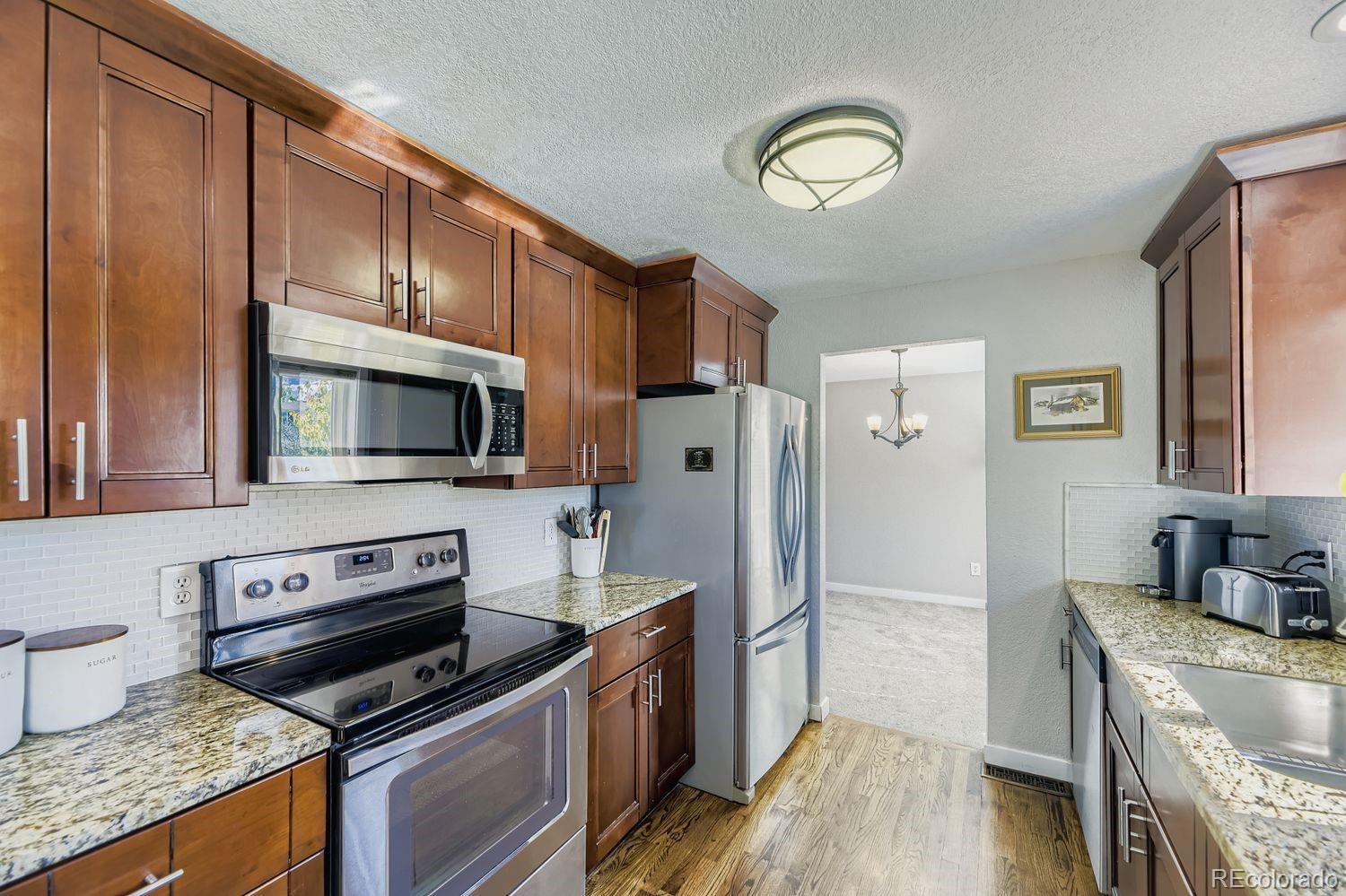 7161 South Franklin Street Centennial, CO 80122 - Photo 5 of 28 a kitchen with stainless steel appliances granite countertop a stove microwave and refrigerator
