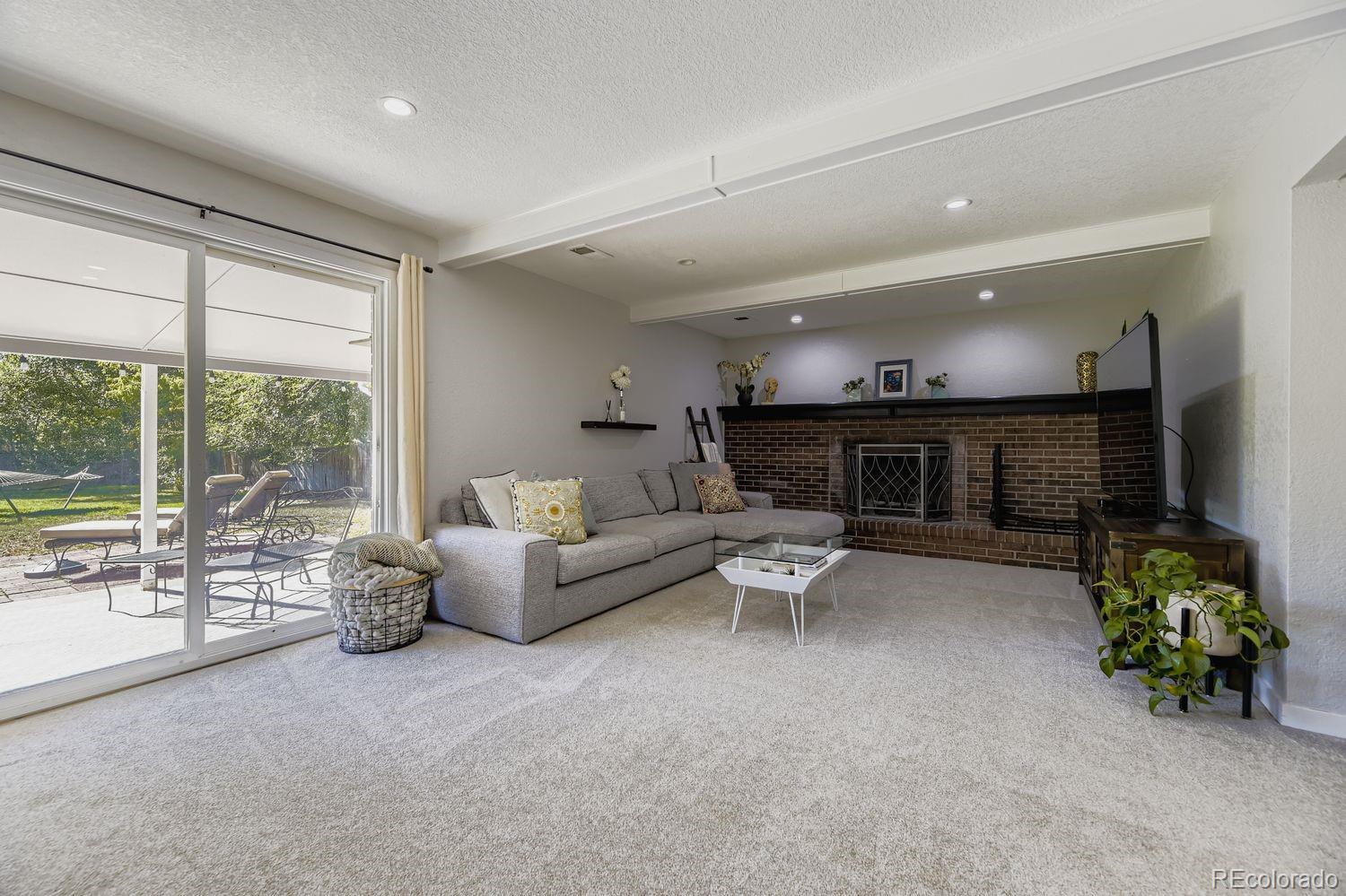 7161 South Franklin Street Centennial, CO 80122 - Photo 8 of 28 a living room with furniture a fireplace and a flat screen tv