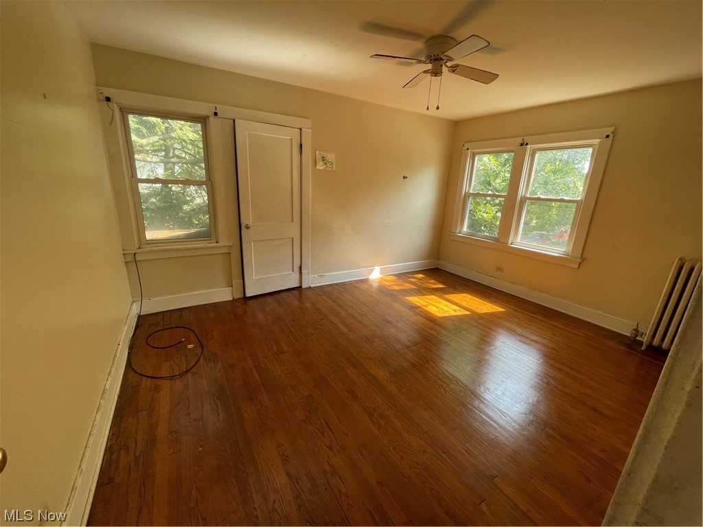 1730 Wood Road Cleveland Heights, OH 44121 - Photo 24 of 34 Unfurnished room featuring wood-type flooring, radiator heating unit, and ceiling fan