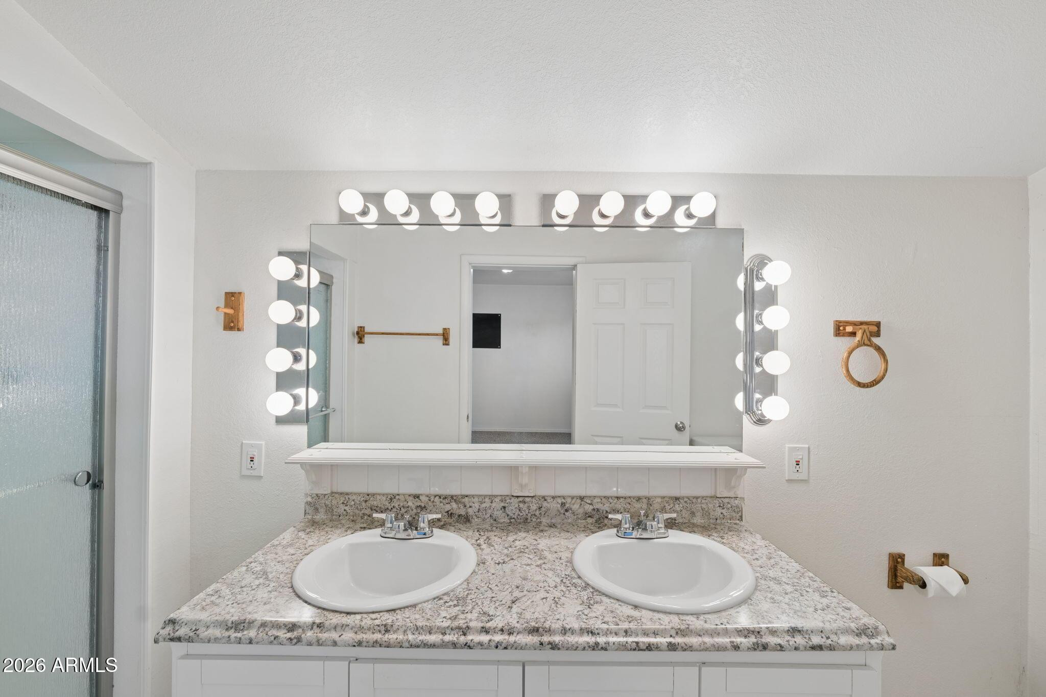 7 South Catalina Street Gilbert, AZ 85233 - Photo 19 of 34 a bathroom with a granite countertop sink a mirror and vanity