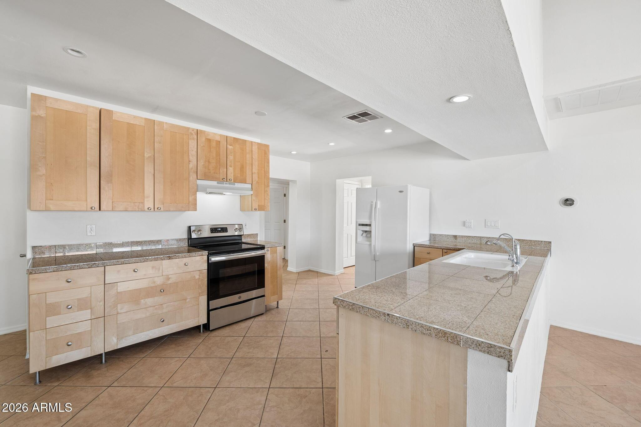 7 South Catalina Street Gilbert, AZ 85233 - Photo 7 of 34 a kitchen with granite countertop a sink and white cabinets