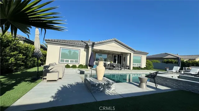 a front view of a house with swimming pool and sitting area