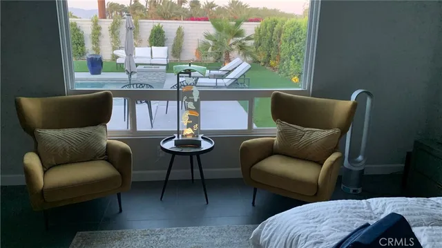 a living room with furniture wooden floor and a large window