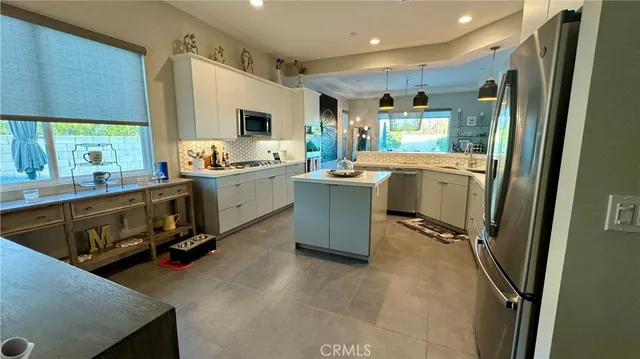 a room with kitchen island a sink stove and refrigerator