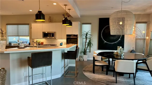a kitchen with a dining table chairs stove and cabinets