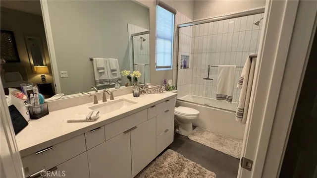 a bathroom with a double vanity sink toilet mirror and shower