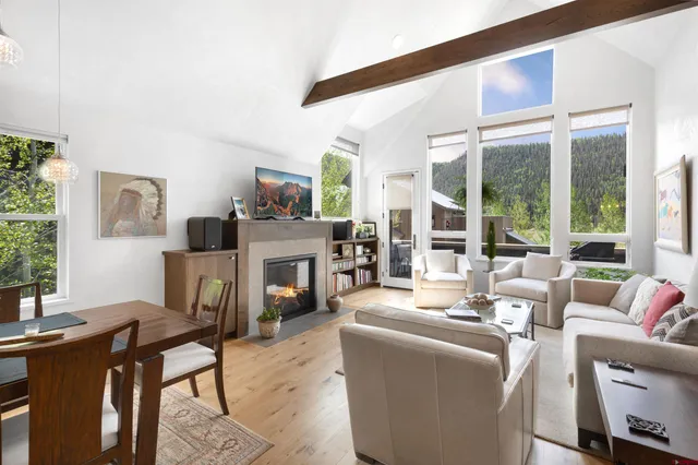 a living room with furniture a large window and a fireplace