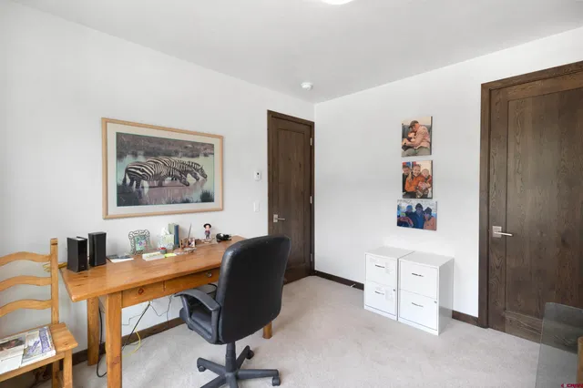 a view of a workspace with furniture and a window