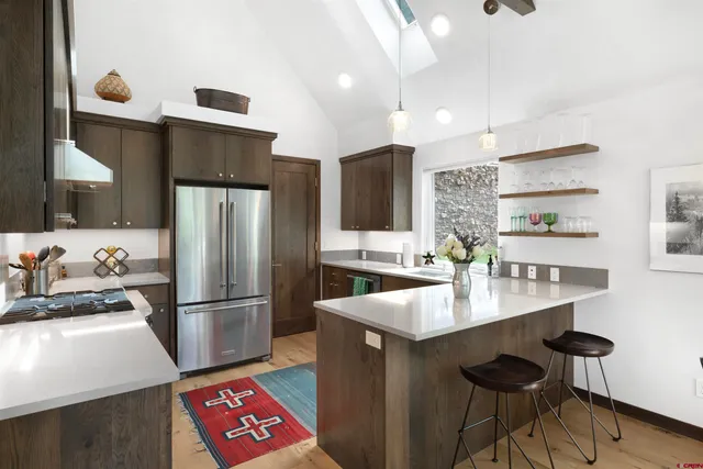 a kitchen with stainless steel appliances granite countertop a refrigerator and a stove top oven