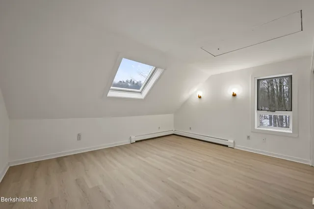 a view of an empty room with wooden floor and cabinet