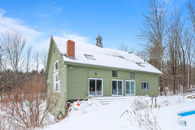 a view of large house with a yard covered in snow