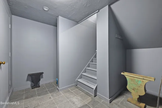 a view of a hallway with chairs and a potted plant in a bathroom