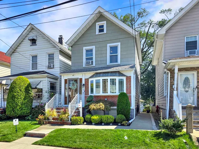 a front view of a house with a yard and potted plants