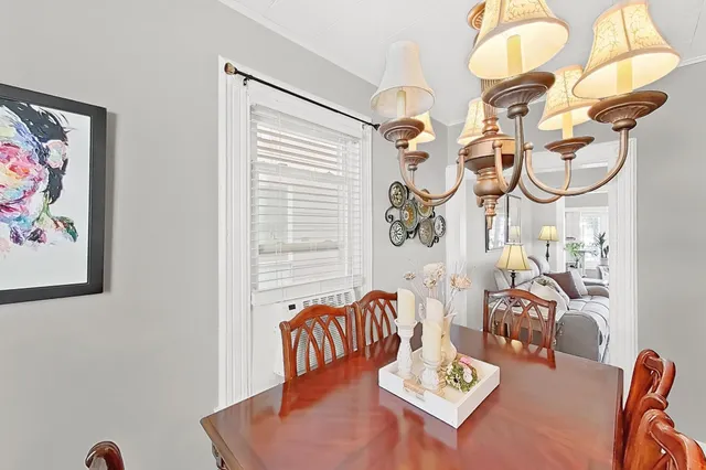 a view of a dining room with furniture a chandelier and wooden floor