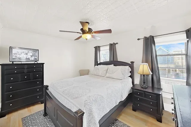a bedroom with a bed a chandelier and a dresser