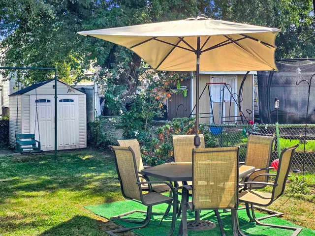 a view of a chair and table in the backyard