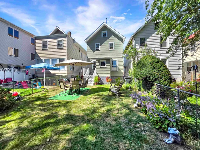 a view of a brick house with a yard and plants