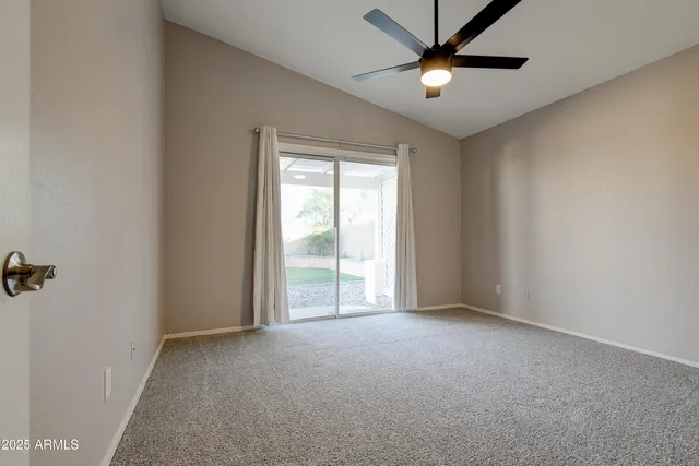 an empty room with fan and entrance