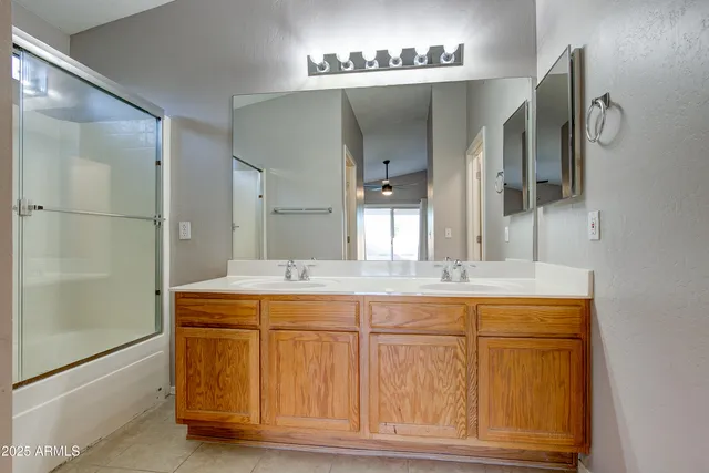 a bathroom with a double vanity sink mirror and shower
