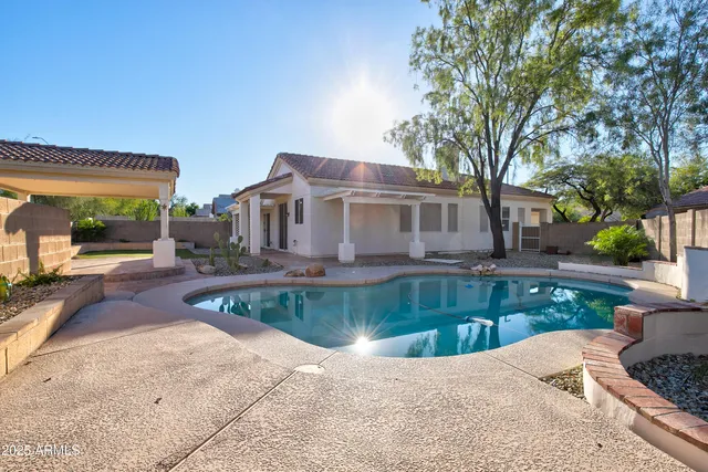 a view of a house with pool fire pit a patio and a yard