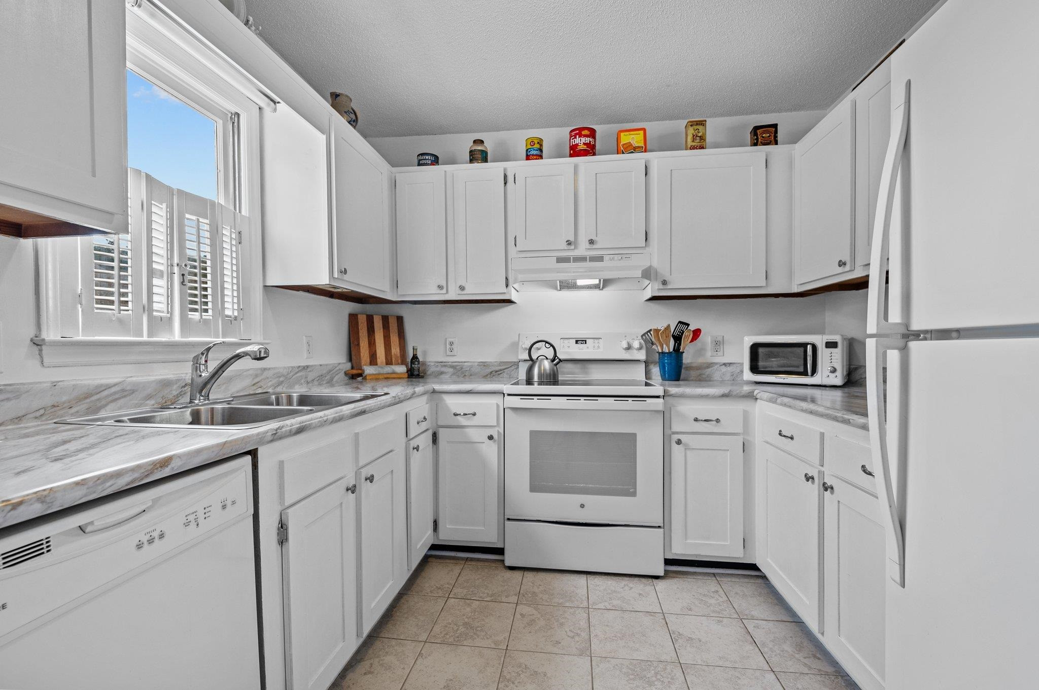 5619 Split Oak Way Raleigh, NC 27609 - Photo 5 of 36 a kitchen with granite countertop cabinets sink and white appliances