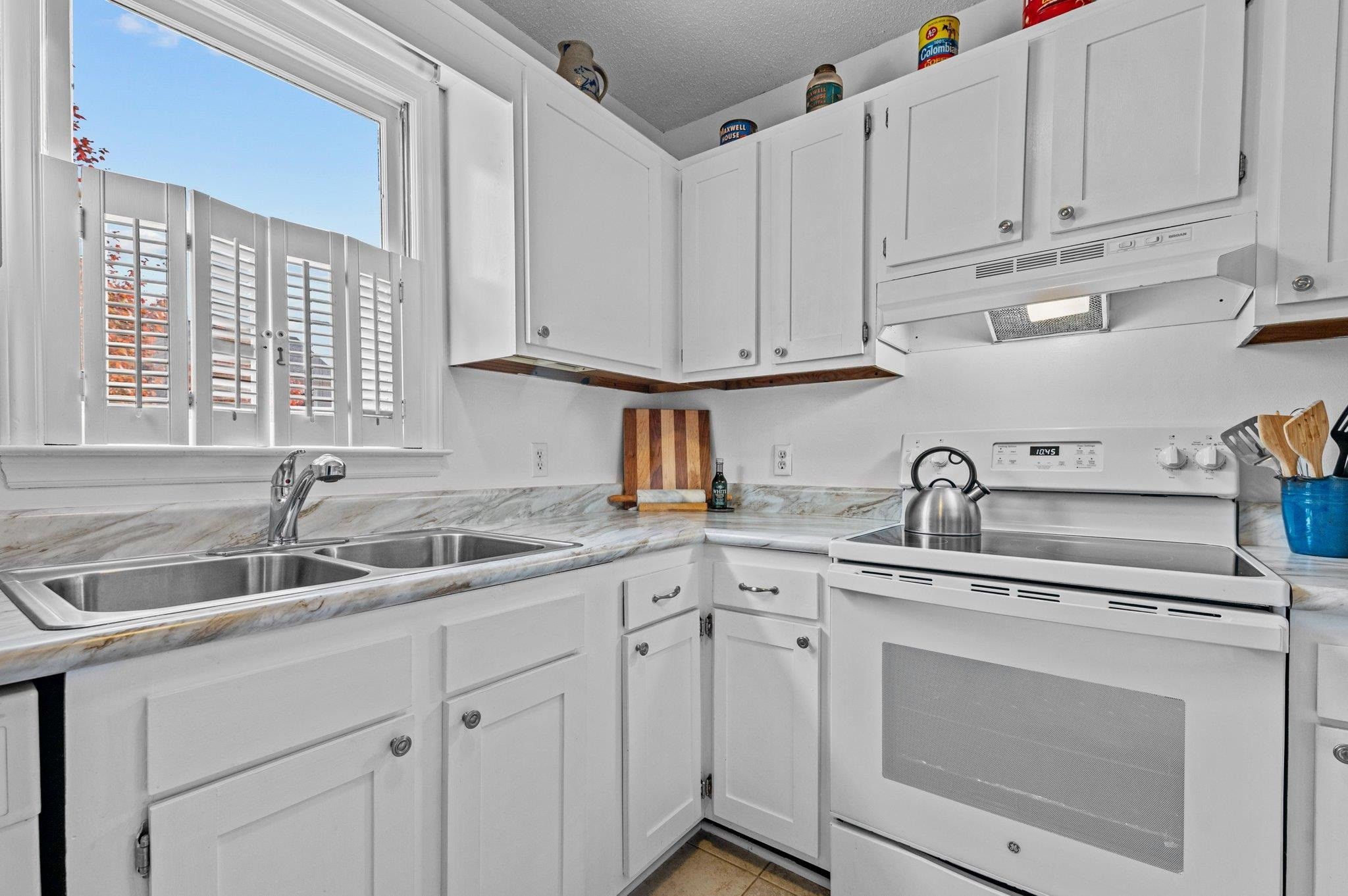 5619 Split Oak Way Raleigh, NC 27609 - Photo 6 of 36 a kitchen with white cabinets sink and window