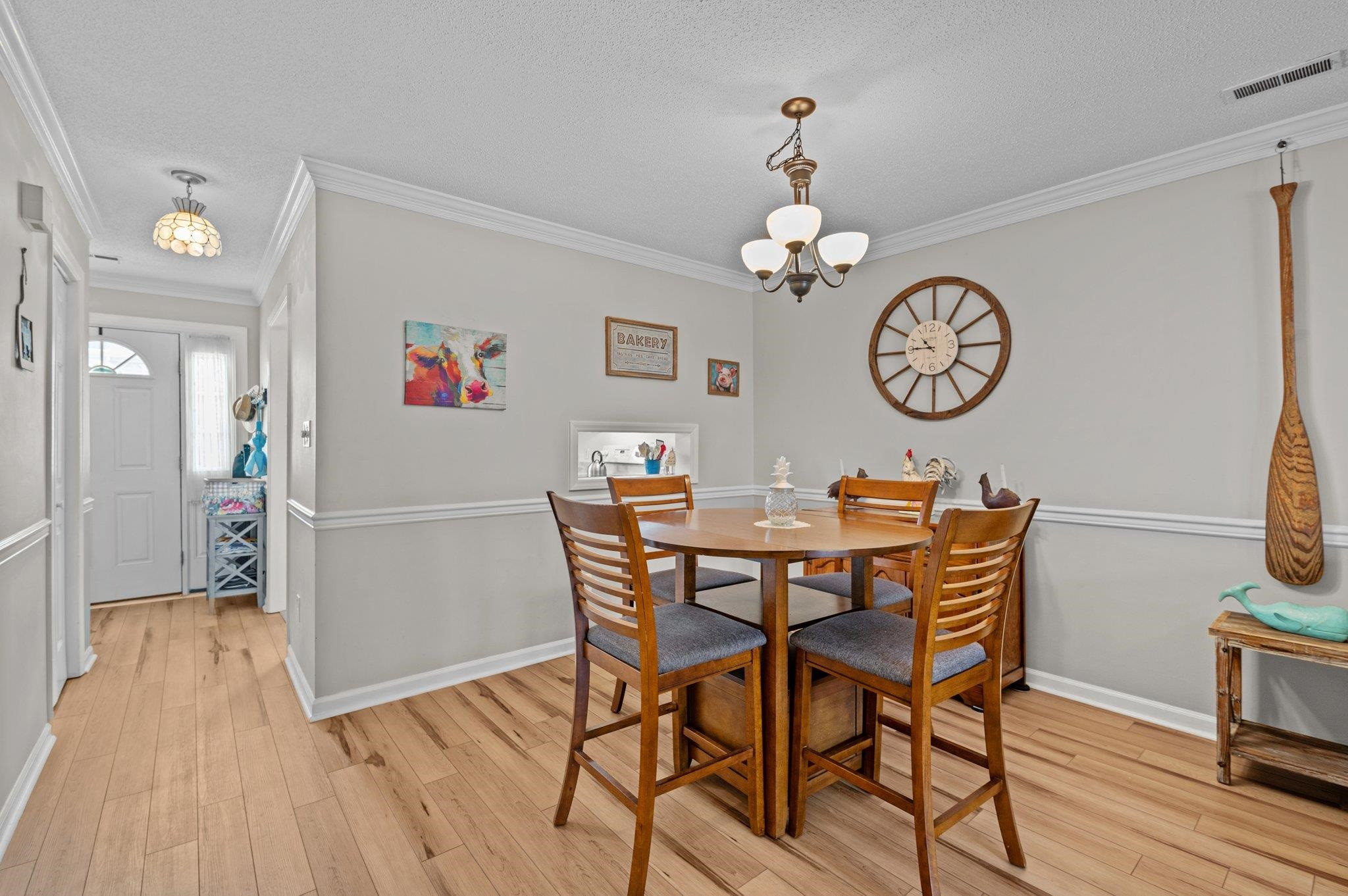 5619 Split Oak Way Raleigh, NC 27609 - Photo 8 of 36 a view of a dining room and livingroom with furniture wooden floor a clock and a view of kitchen