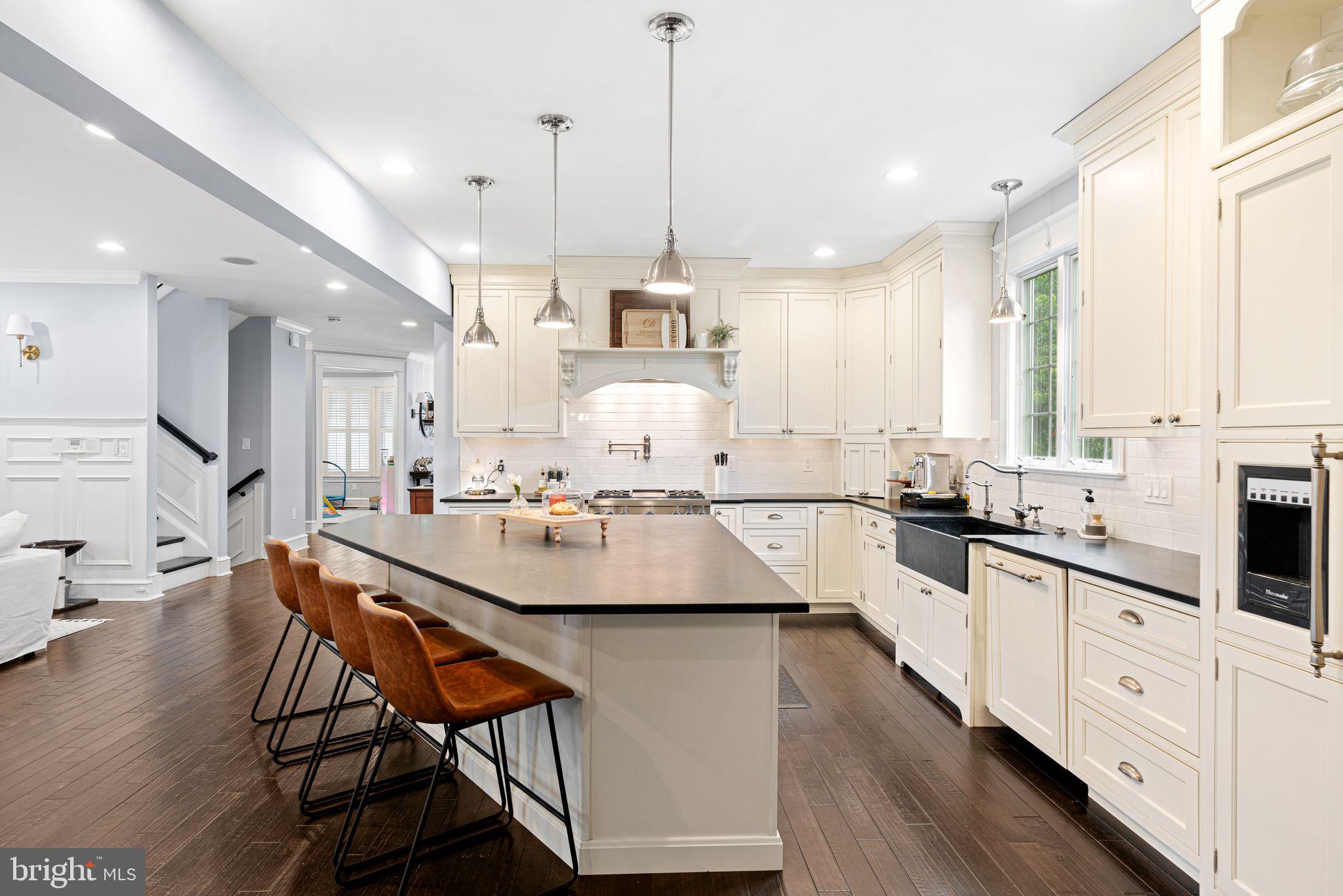 415 Washington Avenue Haddonfield, NJ 08033 - Photo 7 of 51 a kitchen with stainless steel appliances kitchen island granite countertop a sink stove and white cabinets with wooden floor