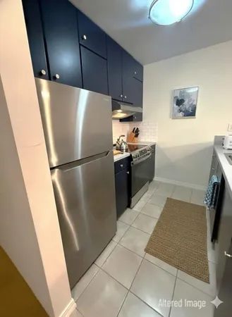 a kitchen with a refrigerator sink and cabinets