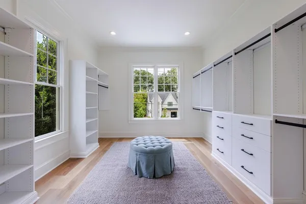 a view of an empty room with wooden floor and a bathroom