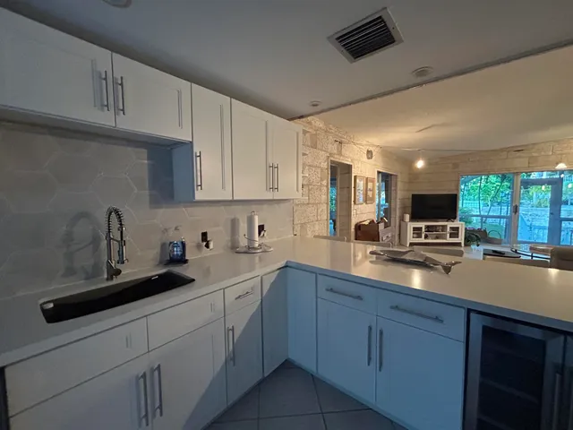 a kitchen with a sink a stove and cabinets