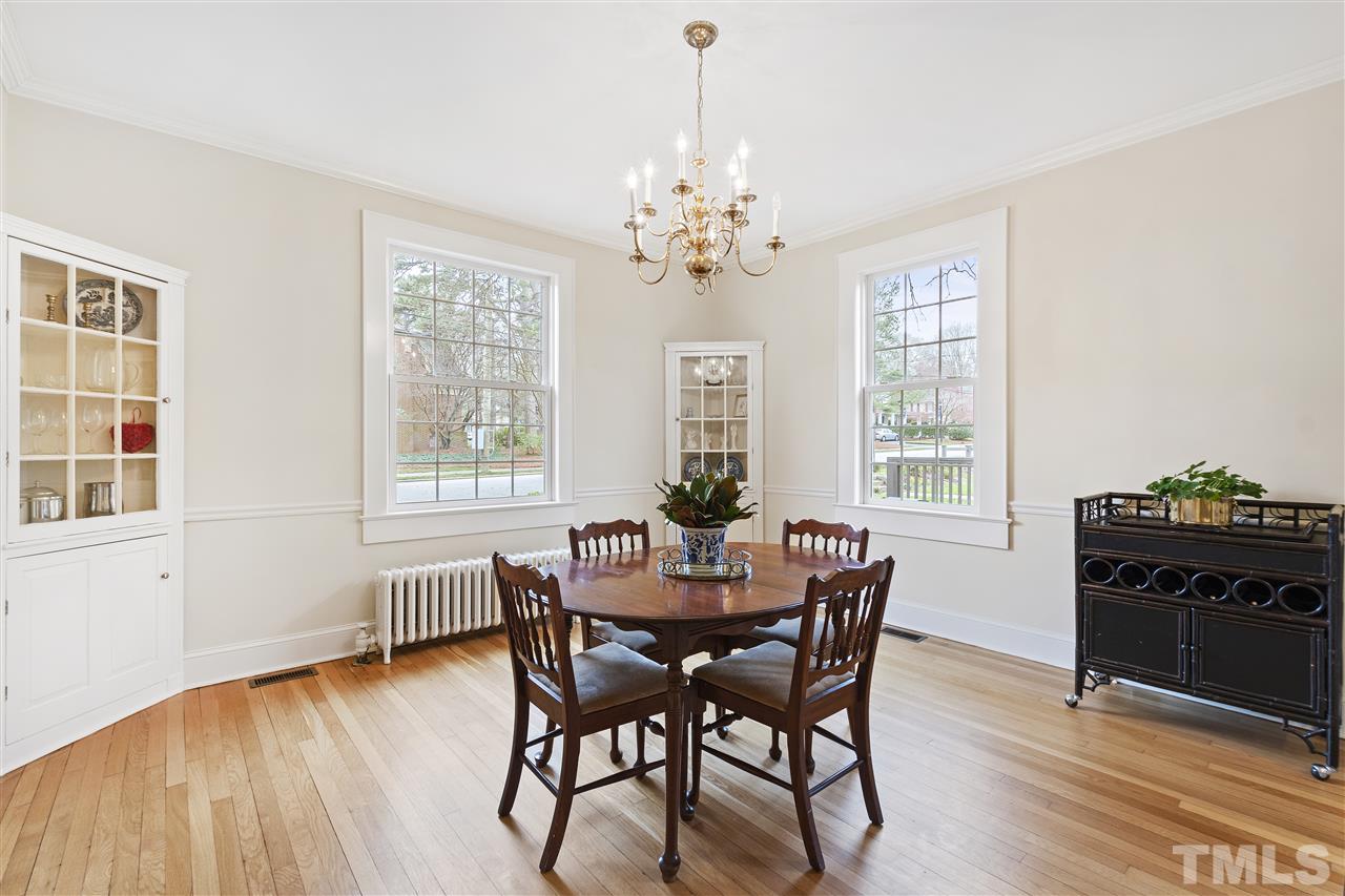 2214 Fairview Road Raleigh, NC 27608 - Photo 6 of 25 a dining room with wooden floor a chandelier a wooden table and chairs