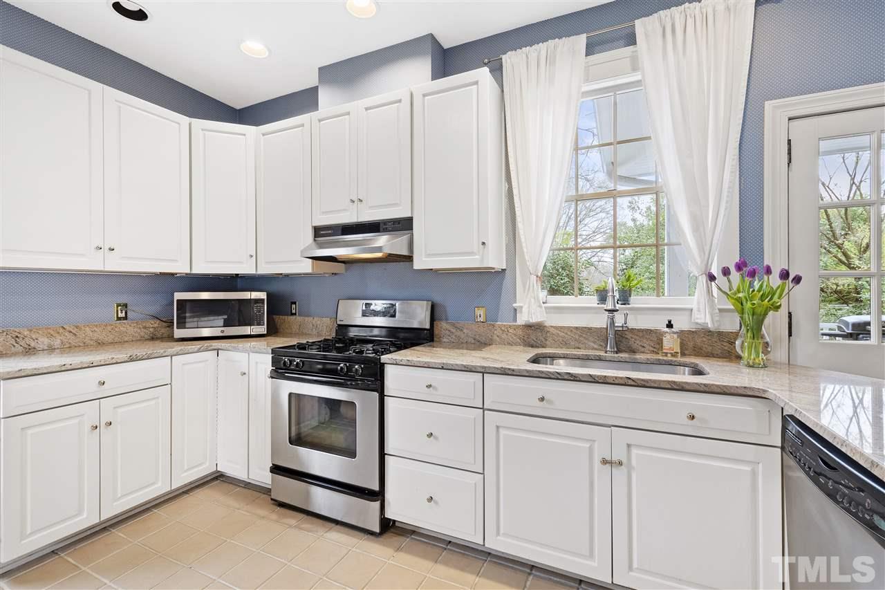 2214 Fairview Road Raleigh, NC 27608 - Photo 8 of 25 a kitchen with granite countertop white cabinets white appliances and a sink