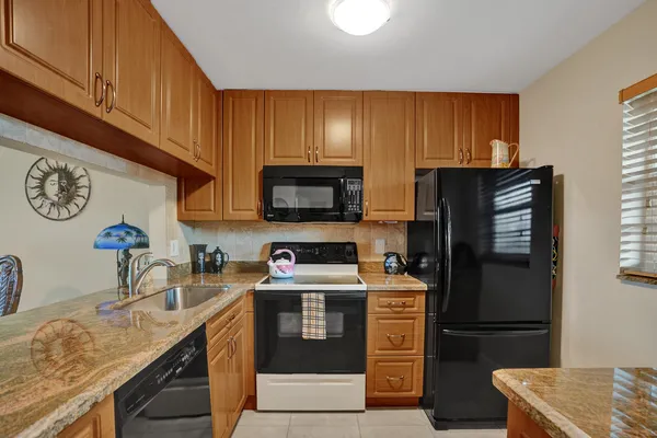 a kitchen with stainless steel appliances granite countertop a refrigerator stove and sink
