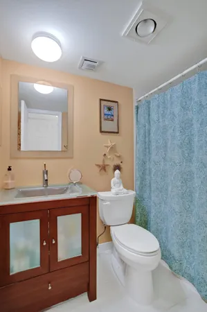 a bathroom with a toilet a sink and mirror