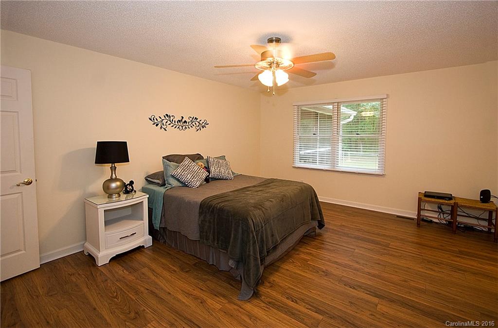 9505 Mini Ranch Road Waxhaw, NC 28173 - Photo 12 of 24 a spacious bedroom with a bed and a chandelier